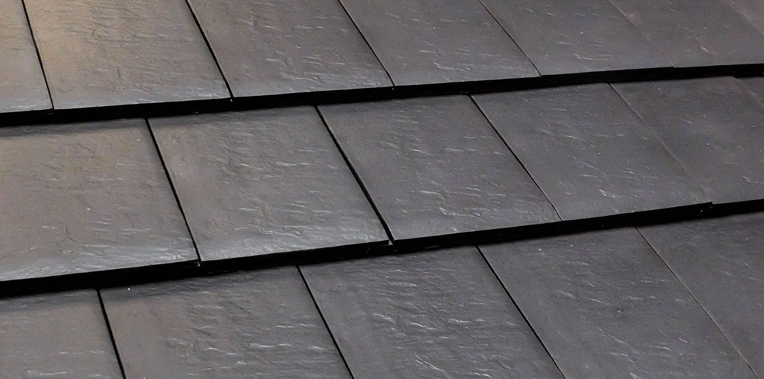 Black slate roof tiles overlapping rows
