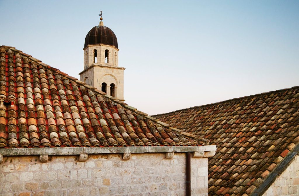 Stone church tower and tiled rooftops