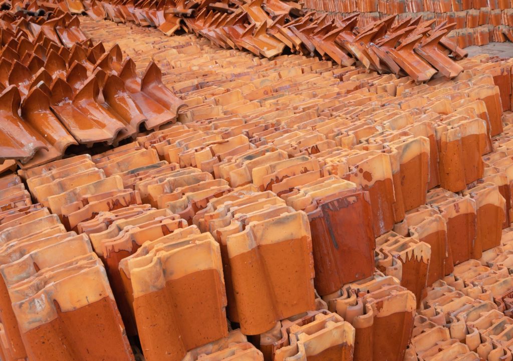 Red clay roof tiles stacked in rows