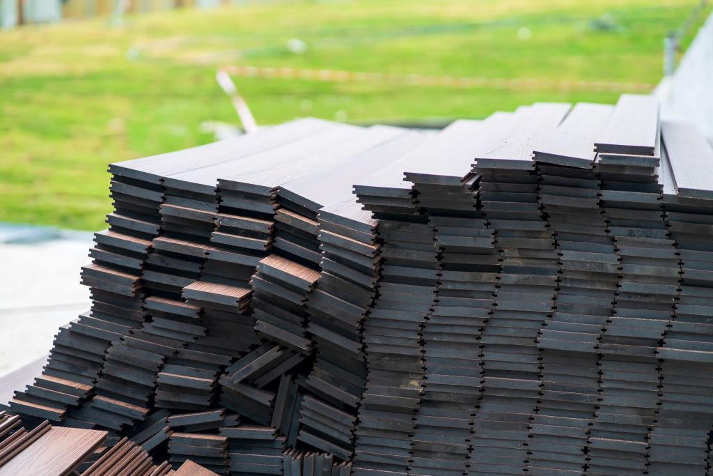 Dark wood flooring planks stacked outdoors